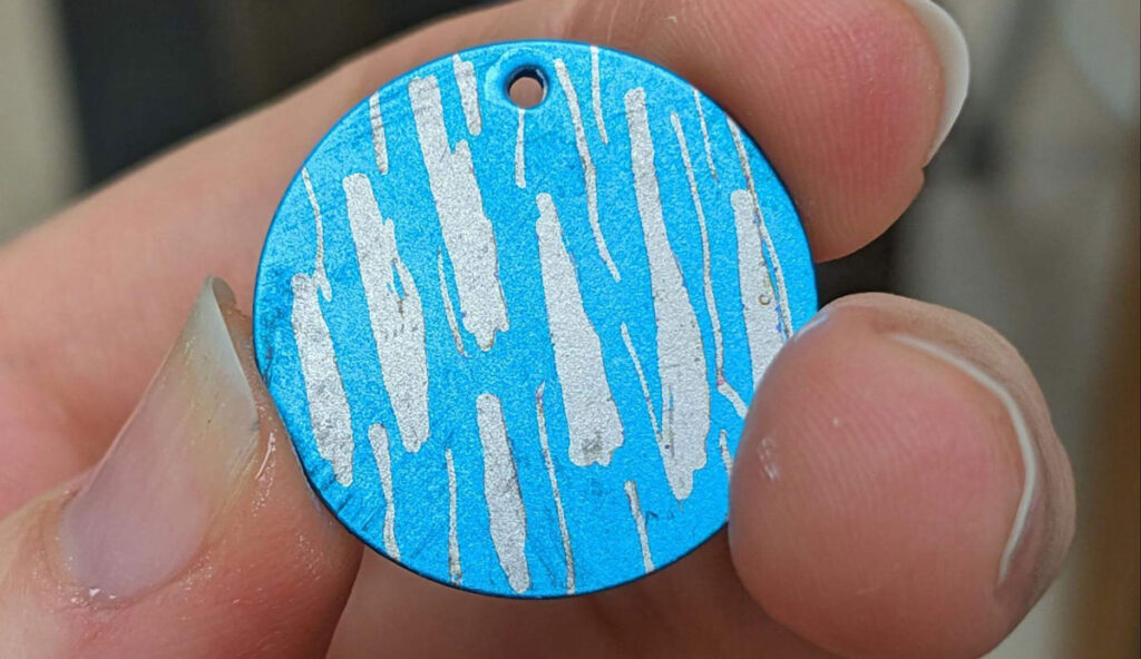Close up image of a bright blue metal disk with silver streaks across it.